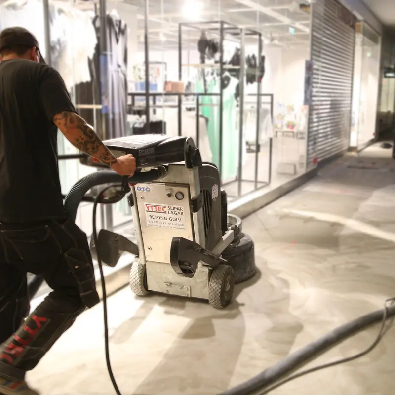 Golvslipning i en galleria med butiker i bakgrunden