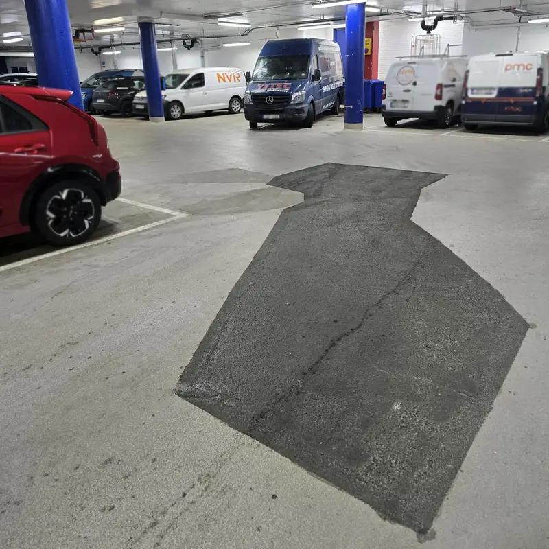 Lagat parti i körbanan i ett parkeringsgarage, med parkerade bilar och Yttecs servicebil i bakgrunden