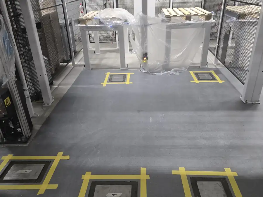 Utsatta lägen för vändplattor markerade med tejp i ett robotgolv